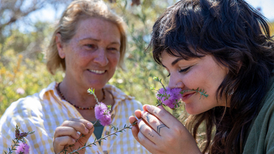 Sylvia Leighton (Wilyun Ponds Farm) with Tiahni Adamson, smelling a flower.