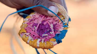Hand holding weaving on Martu Country, Birriliburu Indigenous Protected Area, Western Australia.