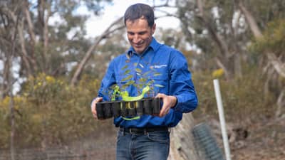 Ecologist Dr Matt Appleby with a tray full of seedlings and a big smile.