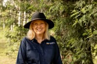 Bush Heritage CEO Rachel Lowry, a smiling, middle-aged woman with shoulder-length blonde hair wearing a Bush Heritage work shirt and broad-brimmed hat.