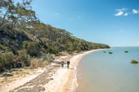 Two men walking on a beach on French Island.