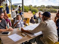 Bush Heritage staff seated at an outdoor table, discussing fire management with locals.