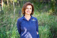 Michelle Stook wearing a Bush Heritage shirt and standing in grasslands.