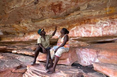 Two people exploring the Rock Art gallery at Ngalkombarli.