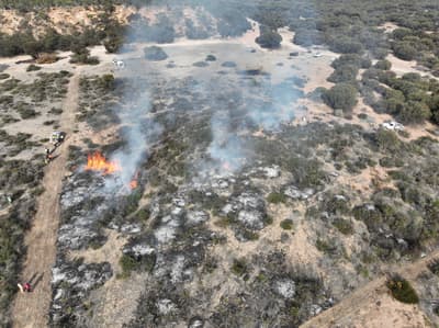 Slow fire and smoke moves across kwongkan shrubland from
a Noongar-led burn at Nowanup.