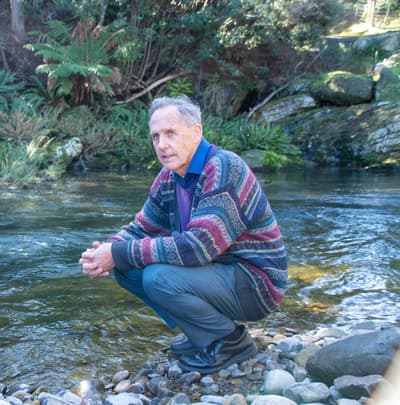 Bob Brown squats by a creek in the Liffey Valley.
