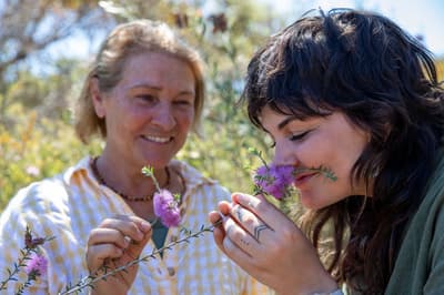 Sylvia Leighton (Wilyun Ponds Farm) with Tiahni Adamson, smelling a flower.
