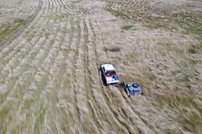 Aerial view of vehicle harvesting bluegrass seeds at Carnarvon Station Reserve.