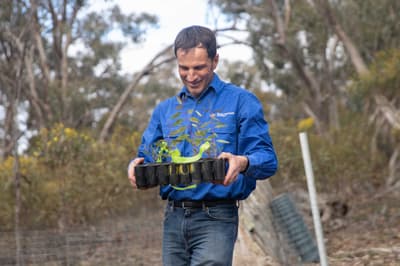 Ecologist Dr Matt Appleby with a tray full of seedlings and a big smile.