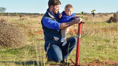 Ecologist Ben Parkhurst planting a tree with toddler son, Liam.
