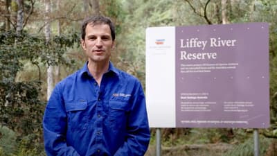 Ecologist Matt Appleby beside sign for Liffey River Reserve.