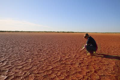 Greg Sousaari surveys an area of dry, cracked mud.