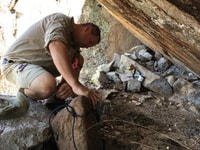 Paul Hales setting a camera trap in a rock wallaby habitat.