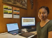 Bush Heritage volunteer Eva You, a young Asian-Australian woman, sitting at the computer in her office.