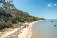 Two men walking on a beach on French Island.