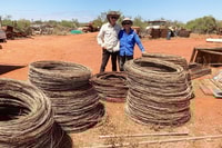 Ian and Annie Mayo with stacked coils of removed fence wire at Hamelin Reserve