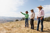 Agro-ecologist Imogen Semmler (centre) observes the farm’s boundaries with farmers Gus and Anna Hickman.