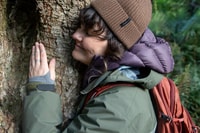 Tiahni Adamson hugs a huge tree in the Liffey Valley, Palawa Country, TAS. Photo Bee Stephens.