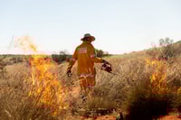 Kyle Barton uses a drip torch to conduct a prescribed burn.