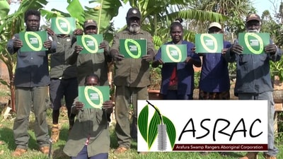 Group from Arafura Swamp Rangers Aboriginal Corporation (ASRAC) holding copies of a publication.