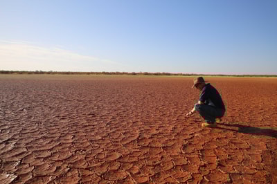 Greg Sousaari surveys an area of dry, cracked mud.